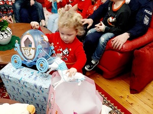 policjanci wspólnie z dziećmi rodzinnego domu dziecka w Ziębicach na Święta Bożego Narodzenia, dzieci rozpakowują prezenty