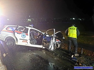 samochód uszkodzony w wypadku- Ford Focus (ambulans) obok mężczyzna w kamizelce odblaskowej policja