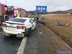 na pierwszym planie biały samochód , droga w tle służby ratunkowe