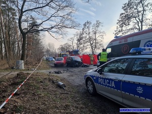 wypadek drogowy, na pierwszym planie radiowóz oznakowany, w tel służby ratunkowe