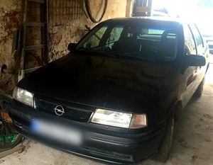 ciemny samochód Opel Vectra stojący pod wiatą garażową