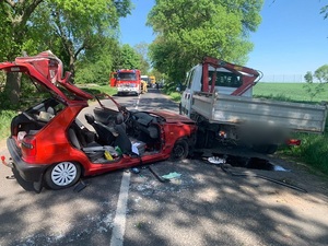uszkodzony czerwony samochód Skoda Felicja oraz Iveco na drodze w tle pojazd straży pożarnej