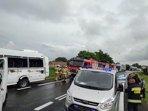ulica, biały bus, karetka służby pogotowia i porządkowe w tle stojące pojazdy