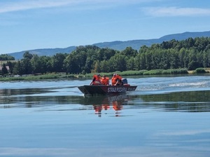 łódka motorowa z załogą na jeziorze w dzień