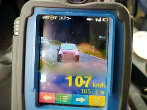 pomiar prędkości na fotoradarze, wyświetlaczu 107 km/h, oraz samochód ciemny przód
