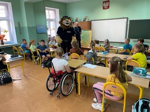 spotkanie policjanta z dziećmi w szkole, dzieci siedzą w ławkach policjant stoi , Komisarz Lew