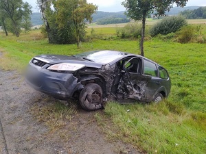 uszkodzony samochód koloru ciemnego na poboczu
