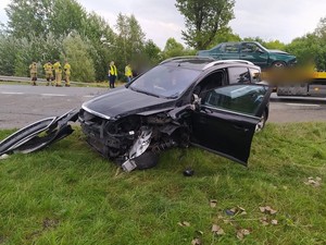 uszkodzony samochód koloru ciemnego na poboczu