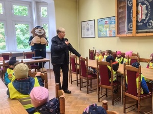 dzieci siedzą przy stołach, pomieszczenie, Komisarz Lew, policjantka