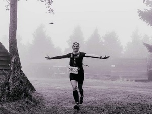 kobieta biegnie z wyciągniętymi rękoma, ubrana na sportowo