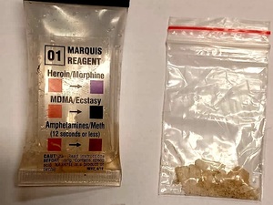 dwa woreczki: jeden z zawartością pomarańczowej substancji, drugi kryształków