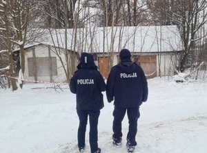 2 policjantów przed ośnieżonym budynkiem
