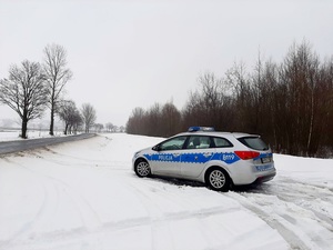 oznakowany radiowóz stojący na śniegu przy drodze