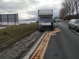 biały samochód dostawczy, uszkodzony stoi na drodze częściowo na poboczu