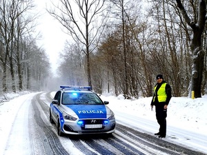 trudne zimowe warunki drogowe, radiowóz obok policjant