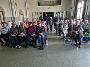 dwóch umundurowanych policjantów na spotkaniu z seniorami