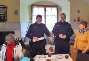 dwóch umundurowanych policjantów rozmawia z seniorami