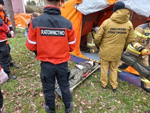 straż pożarna i ratownicy opatrują osoby cywilne przy namiotach