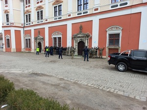 budynek, policjanci, przy budynku osoby stojące w rozkroku z rękami opartymi o ścianę