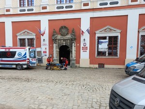pojazd pogotowia ratunkowego przy budynku, ratownicy, osoba na noszach