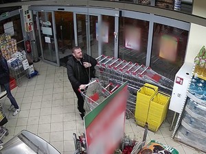 ubrany na ciemno mężczyzna w sklepie ,idzie z wózkiem zakupowym