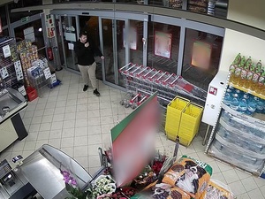 ubrany w ciemną bluzę i jasne spodnie mężczyzna w sklepie przy wejściu