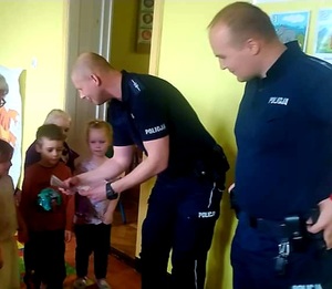 dwóch umundurowanych policjantów wśród dzieci