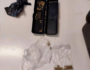etui ciemne po okularach w środku susz roślinny, w torebce przezroczystej obok również marihuana