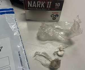 narkotyki w woreczkach, amfetamina i marihuana,za nimi opakowanie od narkotestu