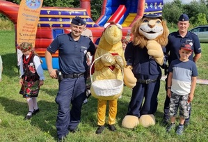 maskotka dolnośląskiej policji Komisarz Lew oraz 2 umundurowanych policjantów na festynie wakacyjnym