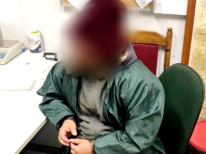 zatrzymany mężczyzna z kajdankami siedzi na krześle