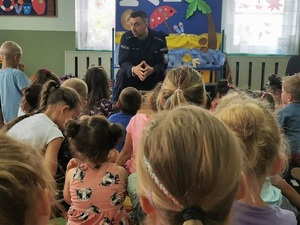 umundurowany policjant rozmawia z dziećmi