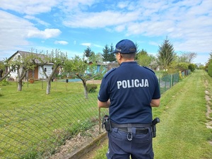umundurowany policjant na terenie ogródków działkowych