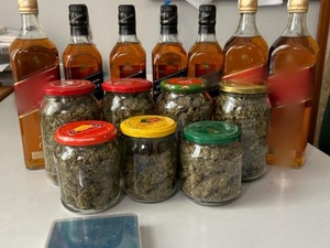 marihuana w 7 słoikach, 7 butelek whisky i waga