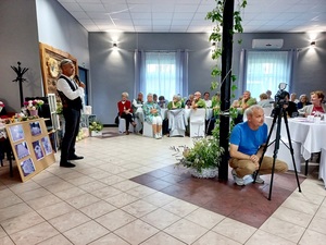 policjant ostrzega seniorów przez zagrożeniami na spotkaniu