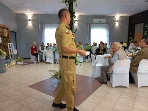 strażak przemawia do seniorów na spotkaniu