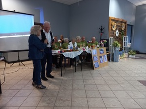 seniorzy siedzą przy stołach na spotkaniu w świetlicy wiejskiej w Laskach