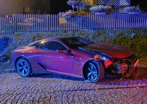 uszkodzony czerwony samochód osobowy Lexus stający na drodze