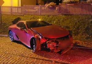 uszkodzony czerwony samochód osobowy Lexus stający na drodze