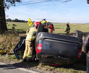 samochód leżący na dachu przy drodze w wyniku wypadku drogowego