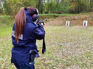 policjantka strzela podczas wyszkolenia strzeleckiego na świeżym powietrzu