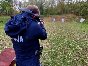 policjant strzela podczas wyszkolenia strzeleckiego na świeżym powietrzu