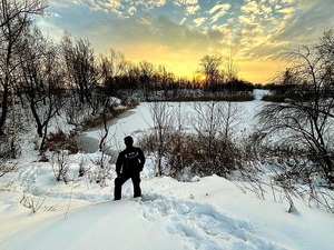 policjant stojący przy zamarzniętym zbiorniku wodnym
