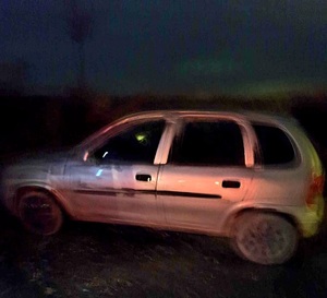 samochód osobowy Opel koloru srebrnego w nocy na drodze gruntowej