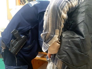 zatrzymany nietrzeźwy kierujący podpisuje dokumenty w obecności policjanta