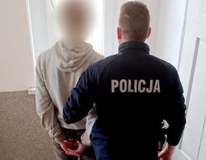 zatrzymany w kajdankach na rękach z tyłu z umundurowanym policjantem
