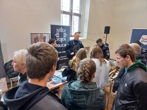 promocja zawodu policjanta na targach pracy w Ząbkowicach Sląskich, umundurowani policjanci przy stoisku promocyjnym z młodzieżą