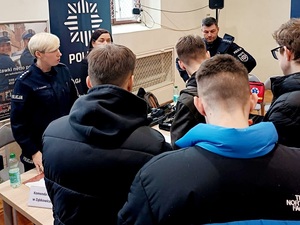 promocja zawodu policjanta na targach pracy w Ząbkowicach Sląskich, umundurowani policjanci przy stoisku promocyjnym z młodzieżą