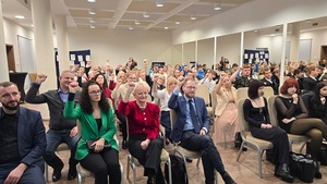 zaproszeni goście konferencja siedzą na krzesłach w pomieszczeniu