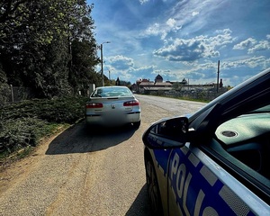 zatrzymany samochód osobowy przez policjantów w oznakowanym radiowozie, kierujący na zakazie